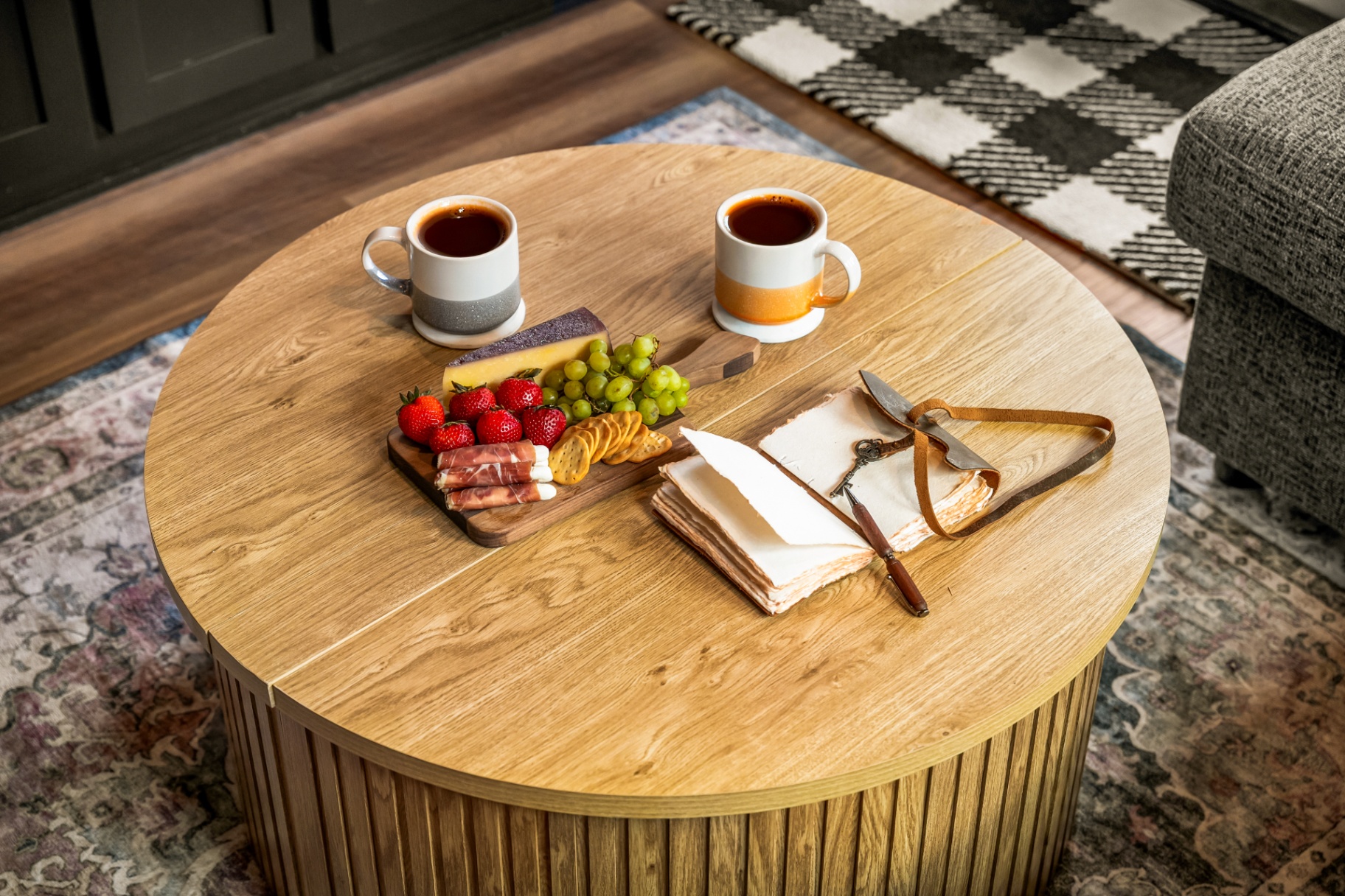 Coffee table with mugs, fruit, and cheese